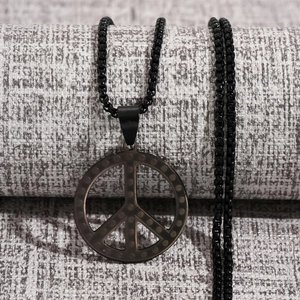 Détail du pendentif signe de paix en acier noir avec texture sur chaîne maille miroir