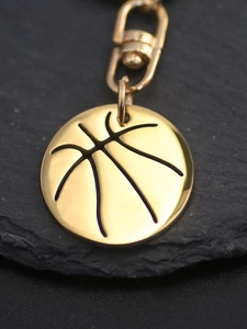 Detailed close-up of a polished gold basketball pendant with a lobster clasp and ring