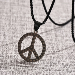 Détail du pendentif signe de paix noir avec texture gaufrée sur acier inoxydable mat