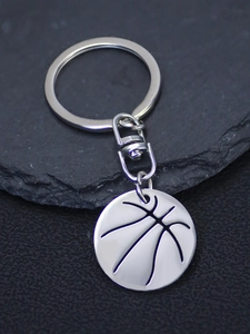 Close-up of a polished silver basketball keychain featuring detailed metal engraving and a ring