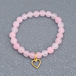 Bracelet élastique en perles roses minimaliste avec un pendentif cœur doré poli