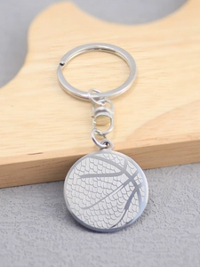 Detailed close-up of a silver basketball pendant keychain with textured metallic finish