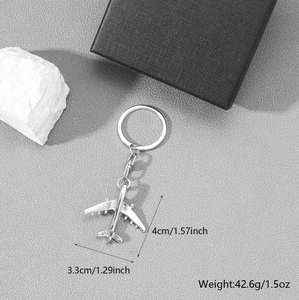 Silver airplane keychain with product dimensions and weights on a grey background