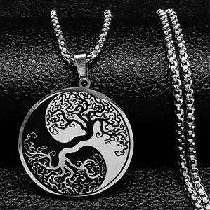 Détail macro du pendentif Arbre de Vie Yin Yang en argent sur fond noir texturé