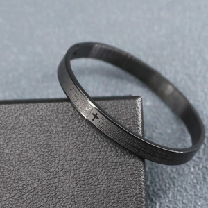 Close-up of black stainless steel bracelet with engraved cross and Italian prayer text