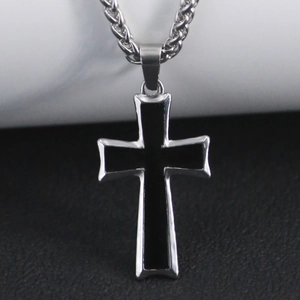 Gros plan d'un pendentif croix argenté minimaliste avec incrustation noire sur chaîne