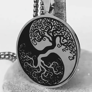 Détail macro de l'Arbre de Vie et du Yin Yang gravés sur un pendentif en acier