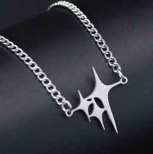 Detailed close-up of a silver Y2K gothic star pendant with a metallic curb chain