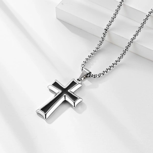 Minimalist silver steel cross pendant necklace with black enamel inlay on a modern white stand