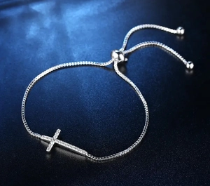 Macro detail of adjustable alloy cross bracelet with zircon inlay and box chain