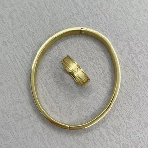 Detail view of gold-plated stainless steel cuff bracelet and Roman numeral ring set