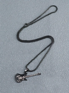 Gros plan détaillé d'un pendentif guitare électrique noire avec des notes de musique