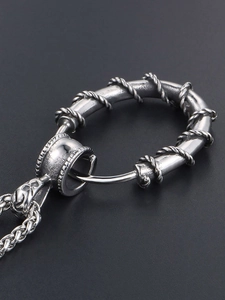 Macro shot of vintage stainless steel ring pendant with textured thorn wire engraving