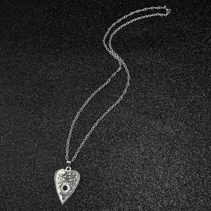 Silver hollow heart Ouija necklace with sun and moon engraving on black background
