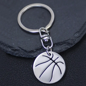 Polished basketball pendant keychain made of stainless steel on dark rock background