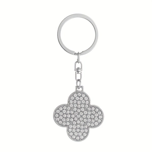 Macro shot of silver four-leaf clover keychain with sparkling crystals and lobster clasp