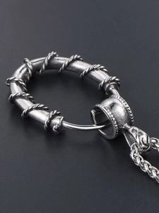 Macro shot of silver thorn-wrapped circle pendant with retro twisted rope texture