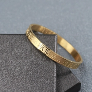 Close-up of golden stainless steel bracelet with engraved Roman numeral scale detail