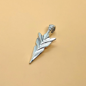 Vintage silver arrowhead pendant necklace with geometric edges on a beige background