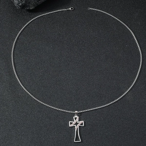 Détail d'un pendentif croix avec coutures de baseball sur une chaîne à maillons