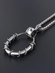 Macro detail of silver vintage stainless steel ring pendant with thorn wire texture
