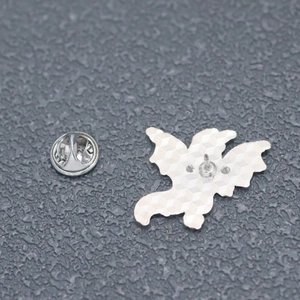 Detail of the silver metal lapel pin back showing butterfly clutch and honeycomb texture