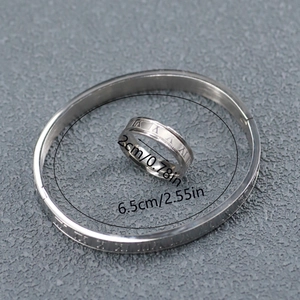 Detail view of silver stainless steel ring and bangle set with Roman numeral engraving