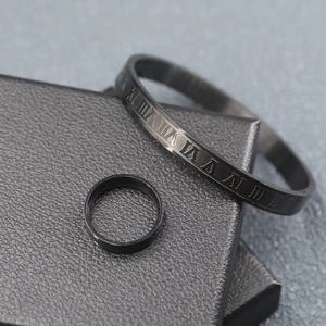 Detail of matte black stainless steel bracelet with Roman numeral engravings and matching ring