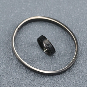 Detailed top view of black stainless steel ring and cuff bracelet set with Roman numerals