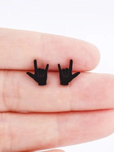 Détail de boucles d'oreilles noires mates en forme de geste tenues pour la taille