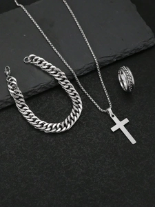 Detailed view of silver stainless steel cross necklace, curb bracelet and chain ring set