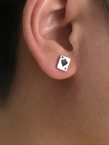 Close-up of a silver-toned Ace of Spades poker card stud earring worn on the ear