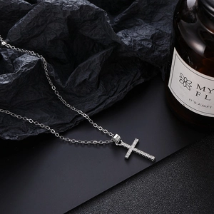 Collar con colgante de cruz y circonitas sobre fondo negro elegante para mujer