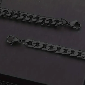 Set aus zwei schwarzen matten Panzerarmbändern mit Karabinerverschluss auf schwarzem Grund