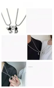 Detail of magnetic heart astronaut pendants connecting on silver steel necklaces