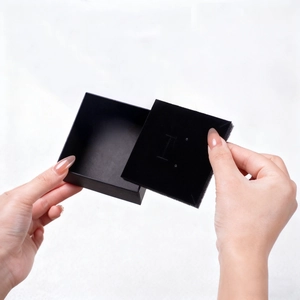 Minimalist matte black jewelry gift box with velvet insert being held in hands