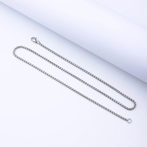 Detailed view of silver stainless steel box chain with lobster clasp and metallic luster