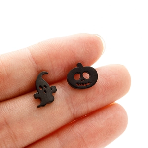Macro shot of Halloween ghost and pumpkin stud earrings in black stainless steel finish