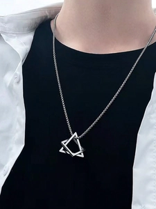 Detail of interlocking triangle geometric pendant on silver stainless steel chain for men