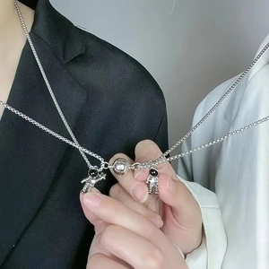 Magnetic astronaut couple necklaces featuring silver heart attraction pendants