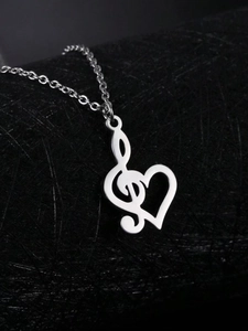 Detail of silver treble clef heart pendant necklace on a premium black fiber background