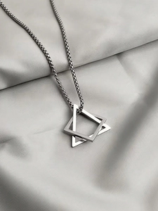 Macro detail of geometric double triangle pendant on a silver box chain necklace