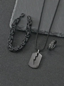 Dettaglio set di gioielli da uomo in acciaio nero con collana a fulmine e anello chic