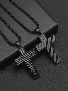 Détail macro de pendentifs croix en acier noir avec gravure de prière et motifs d'étoiles