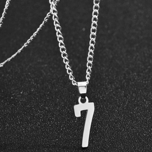 Collier avec pendentif chiffre 7 en acier inoxydable poli argent sur fond noir texturé