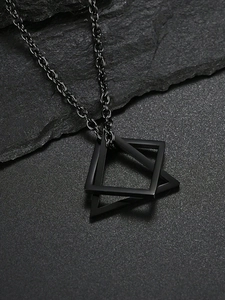 Macro detail of matte black geometric double triangle pendant on a textured rock background