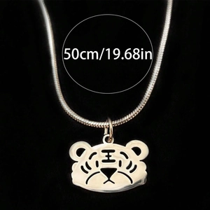 Vue macro du pendentif tête de tigre avec chaîne serpent de 50cm sur fond noir