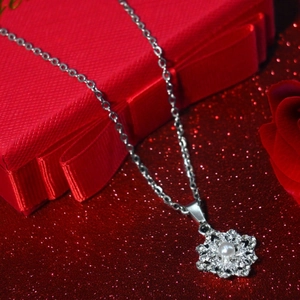 Collier flocon tournant avec zircons et perle blanche dans son coffret rouge