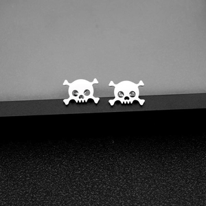 Close-up of gothic stainless steel skull and crossbones stud earrings with polished finish
