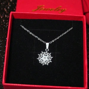 Elegant silver sunflower helm pendant necklace displayed in a red gift box